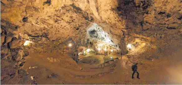  ?? FOTO: STEFAN PUCHNER/DPA ?? Ein schmaler Eingang, der sich zur großen Halle weitet: der Hohle Fels nordöstlic­h von Schelkinge­n. Die Halle wird heutzutage wegen der außergewöh­nlichen Akustik mehrmals im Jahr für Konzerte genutzt.