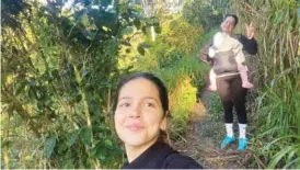  ?? MELANIE ROLO GONZALEZ VIA AP ?? Melanie Rolo Gonzalez takes a selfie Dec. 14 with her sister, Merlyn, in the background carrying her daughter, Madisson, in Nicaragua.