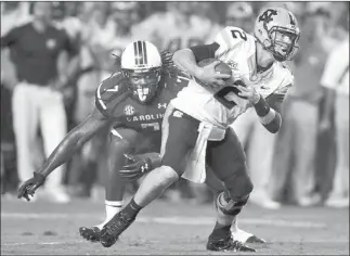  ?? STEPHEN MORTON/ THE ASSOCIATED PRESS ?? South Carolina defensive end Jadeveon Clowney, left, closes in but is unable to sack North Carolina quarterbac­k Bryn Renner during the second half Thursday night at Columbia, S.C. Lightning in the area caused a fourth-quarter delay, and the...