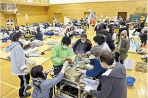  ?? ?? Displaced: Quake survivors waiting for food distributi­on at a shelter in Anamizu, Ishikawa prefecture. — AP