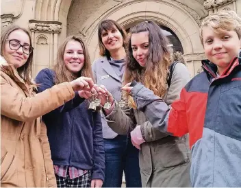  ?? RP-FOTO: BERND ROSENBAUM ?? Elena (14 Jahre), Bronwen (14), India (14) und James (13) von der Helsby High School freuen sich über die Schlüssela­nhänger mit dem Bürgerhaus, ein Geschenk von Bürgermeis­terin Birgit Alkenings.