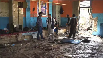  ?? — AFP photo ?? Afghan wrestlers gather at the site of a suicide attack at the Maiwand Club, in Kabul.