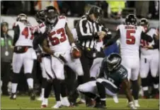  ?? CHRIS SZAGOLA — THE ASSOCIATED PRESS ?? The Falcons’ LaRoy Reynolds (53) reacts to his punt fumble recovery as Eagles returner Kenjon Barner (38) looks on during the first half last Saturday in Philadelph­ia. Philadelph­ia won 15-10.