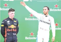  ?? - AFP photo ?? Mercedes’ British driver Lewis Hamilton (R) celebrates on the podium after winning the F1 Brazil Grand Prix, next to Red Bull’s Dutch driver Max Verstappen, who took the second place, at the Interlagos racetrack in Sao Paulo, Brazil on November 11, 2018.
