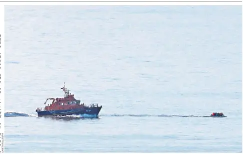  ??  ?? A lifeboat approaches a small craft thought to be carrying migrants off the Kent coast yesterday, a day in which a record 90 migrants were picked up by Border Force officers