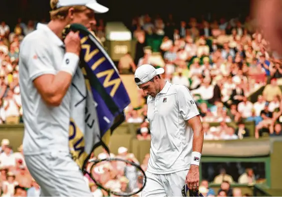  ?? Glyn Kirk / Associated Press ?? Friday’s Wimbledon semifinal between Kevin Anderson, left, and John Isner took 6 hours, 36 seconds to complete before Anderson prevailed 26-24 in the fifth set.