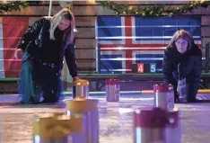  ?? NICOLAS GALINDO/ COLUMBUS DISPATCH ?? Katie Brewer, left, and Kathleen Brewer play curling using mini-kegs on ice at Land-grant.