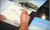  ?? XINHUA ?? A professor of Shaanxi Normal University writes an admission letter with a brush in Xi’an, Shaanxi province.