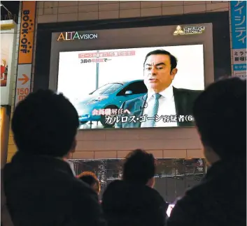  ?? PHOTO D’ARCHIVES ?? Des passants regardent un écran montrant une émission d’actualités présentant le président déchu de Nissan, Carlos Ghosn, dans le centre-ville de Tokyo.