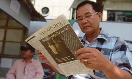  ?? AFP PIC ?? A Cambodian man reading the ‘Cambodia Daily’ in Phnom Penh yesterday.