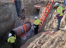  ??  ?? In this April 13 photo provided by TC Energy, contractor­s install a section of the Keystone XL crude oil pipeline at the U.S.-Canada border north of Glasgow, Mont.