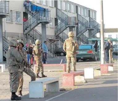  ?? PICTURE: LEON KNIPE ?? CLAMPING DOWN: SANDF members stand guard after a crime swoop, part of Operation Fiela, in Hanover Park yesterday morning. However, a city councillor says these raids are not an effective strategy.
