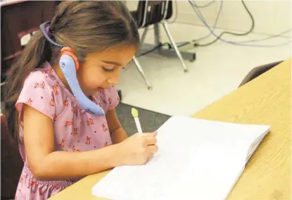  ?? Courtesy ?? Pupil Aaliyah Castillo, 5, uses a Whispering Wonders device in Margarita Garcia’s class at Oaks Elementary School in the Humble school district. A grant from the Humble ISD Education Foundation funded the devices, which help teach volume control and...