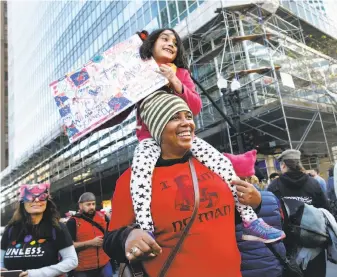  ?? Paul Chinn / The Chronicle ?? Patrina Williams carries her goddaughte­r, Xochitl Catanzano-Rios, 6, on her shoulders in Oakland.