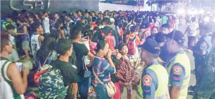  ?? ALDO NELBERT BANAYNAL ?? A huge volume of passengers trying to get a ride home in time for the observance of the All Saints’ Day spill over outside of the Cebu South Bus Terminal Wednesday evening.