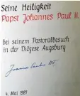  ??  ?? Bucheintra­g mit der Unterschri­ft des Papstes aus dem Jahr 1987.