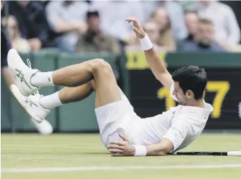  ?? (IAN WALTON/POOL VIA AP) ?? El serbio Novak Djokovic se cae en el encuentro ante sudafrican­o Kevin Anderson en la segunda ronda del torneo de Wimbledon.