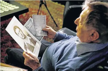  ?? REUTERS ?? Holocaust survivor Avraham Harshalom, 95, looks at a photograph of himself as a young man during an interview with Reuters at his home in Ramat Gan, Israel on Dec. 24, 2019.