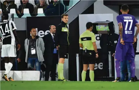  ?? (ALBERTO PIZZOLI/AFP PHOTO) ?? L’arbitre analyse une séquence de jeu sur vidéo lors d’un match entre la Juventus et La Fiorentina. Le recours à la VAR a tendance à hacher le jeu.