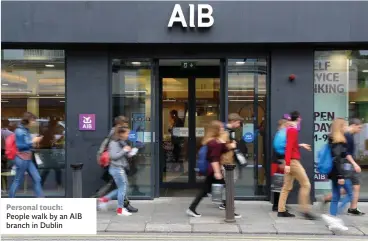  ??  ?? Personal touch: People walk by an AIB branch in Dublin