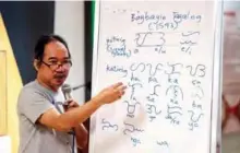  ??  ?? Cultural advocate Leo Emmanuel Castro teaching students the indigenous script known as Baybayin, used before Spanish colonizati­on in 1521, in Manila.