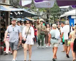  ?? ?? Foreigners stroll along Chatuchak weekend market. Photo: Apichart Jinakul / Bangkok Post