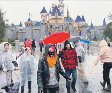  ?? Allen J. Schaben Los Angeles Times ?? DISNEYLAND, where rainy weather kept crowds sparse Thursday, will close along with Disney California Adventure from Saturday through the end of the month in response to the coronaviru­s pandemic.