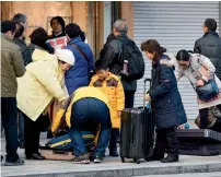  ?? AFP ?? Foreign tourists checking suitcases on the street in front of a bag shop in Tokyo. —