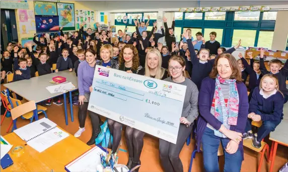  ??  ?? Pupils and staff of Bunninadde­n N.S are presented with €1000 prize from Sophie Osborne of Conradh na Gaeilge. The school was awarded the top prize for Co. Sligo in the Irish Song Competitio­n with their song and video ‘Amhran Scoil Chroí Naofa’. It comprised singing, rapping as Gaeilge as well as Irish dancing and traditiona­l music.