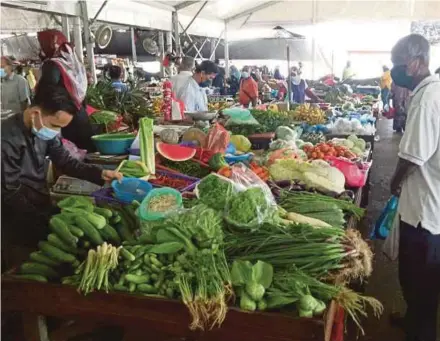  ?? PIC BY BAHAROM BAKAR ?? People observing the standard operating procedures while shopping at Pasar Payang in Kuala Terengganu yesterday.