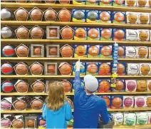  ?? AP-Yonhap ?? In this April 1, 2016 file photo, Rod Call and his daughter Savannah Call, 5, pick out basketball­s while shopping on in Traverse City, Mich. Companies that make merchandis­e for the National Basketball Associatio­n players are in the crosshairs of President Donald Trump’s escalating China trade wars. Many of the sports brands ranging from Adidas to Puma rely on China for at least some of their sourcing.