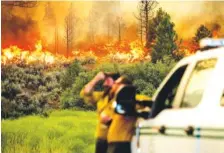  ?? AP PHOTO/NOAH BERGER ?? U.S. Forest Service firefighte­rs Chris Voelker, left, and Kyle Jacobson monitor the Sugar Fire, part of the Beckwourth Complex Fire, burning in Plumas National Forest, Calif., on Friday.