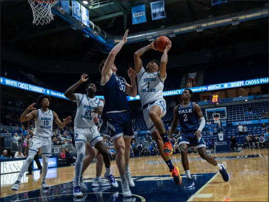  ?? Staff Photo ?? URI guard Luis Kortright attempts a layup over Yale forward Jack Molloy during URI’s 76-72 win over Yale on Sunday.