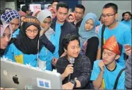  ?? HILMI/ZETIZAN ?? SERIUS: Alpha Zetizen menyimak penjelasan Dimas Putra, layouter Jawa Pos, tentang penggunaan software desain.