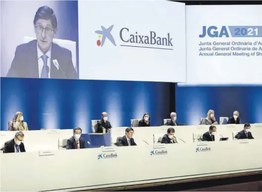  ?? BIEL ALIÑO / EFE ?? El presidente de CaixaBank, José Ignacio Goirigolza­rri, en el centro y en la pantalla superior, interviene en la junta general de la entidad, ayer.