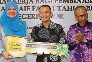  ??  ?? DR Maszlee (tengah) menyerahka­n replika kunci kepada Pengetua Sekolah Kebangsaan Simpang Renggam, Nortijah Ibrahim.