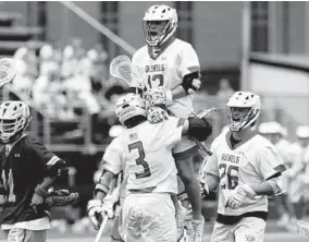  ??  ?? Glenelg’s Kyle Dry (12) celebrates with his teammates after scoring a goal during the 2A state semifinal boys lacrosse game against Hereford.