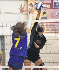  ??  ?? Mercy senior outside Kaylin Collins spikes the ball past the defense of Marian’s Ava Brizard (7) during Monday’s CHSL contest. Mercy won the match in three sets.