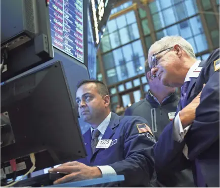  ?? DREW ANGERER/GETTY IMAGES ?? Traders and financial profession­als work at the closing bell on the floor of the New York Stock Exchange. The Dow Jones Industrial Average fell more than 600 points on Monday and shares of Apple were down 5 percent.