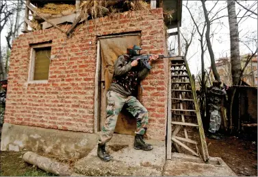  ?? REUTERS ?? Army soldiers take their positions near the site of a gunbattle, where suspected terrorists were holed up, on the outskirts of Srinagar, on Thursday.