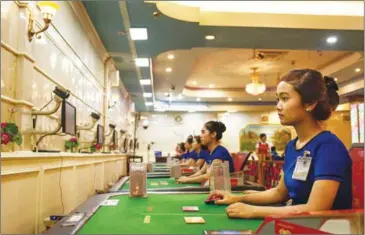  ?? VICTORIA MØRCK MADSEN ?? A croupier sits at a game table in a Bavet casino earlier this year as the game is transmitte­d to patrons via webcam.