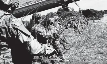  ?? JOHN MOORE/GETTY ?? U.S. Army active duty troops from Ft. Riley, Kan., lay out razor wire along the Rio Grande at the U.S.-Mexico border.