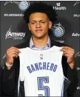  ?? JOHN RAOUX — THE ASSOCIATED PRESS ?? No. 1 draft pick Paolo Banchero shows off Magic jersey on Friday in Orlando, Fla.