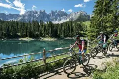  ?? ?? Sopra, in bici lungo il lago di Carezza. A fianco, sulla nuova cabina cabrio che sale da Tires; passeggiat­e e scoperte per i bimbi.