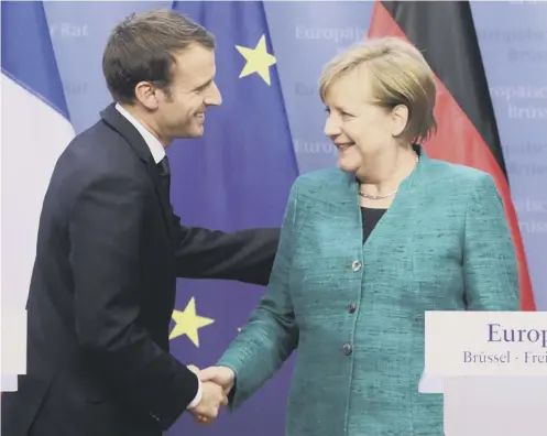  ??  ?? French president Emmanuel Macron shakes hands with German chancellor Angela Merkel at the end of an EU summit in Brussels