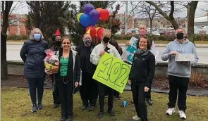  ?? Special to The Daily Courier ?? Employees of the Save on Foods grocery store in the Mission wish Elsie Chandler a happy 102nd birthday. Below, Chandler greets well-wishers at her window.