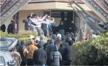  ?? Photo / George Heard ?? The body of Kyah Kennedy is carried into the marae as Southland students pay respect with a haka.