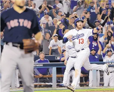  ?? DAVID J. PHILLIP/ASSOCIATED PRESS ?? Los Angeles Dodgers’ Max Muncy scores on a throwing error during the 13th inning of Friday’s Game 3 in Los Angeles.