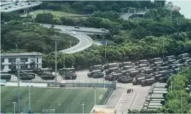  ?? Trucks and armoured personnel carriers parked outside a stadium in Shenzhen, across the border from Hong Kong. ?? Photograph: AFP/Getty Images