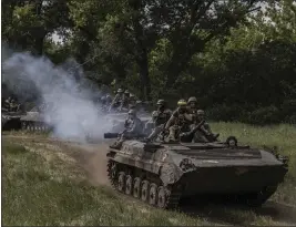  ?? FINBARR O'REILLY — THE NEW YORK TIMES ?? A column of Ukrainian armored vehicles and soldiers travel under the cover of a tree line near the front lines in the Donetsk region of Ukraine on Wednesday.